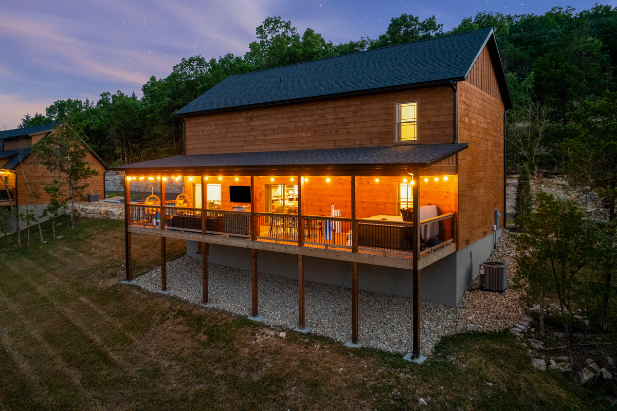 Welcome to Lone Star Lodge, a cedar cabin retreat in Hollister near Branson, Missouri, glowing at sunset with a private hot tub and Ozark Mountain views.