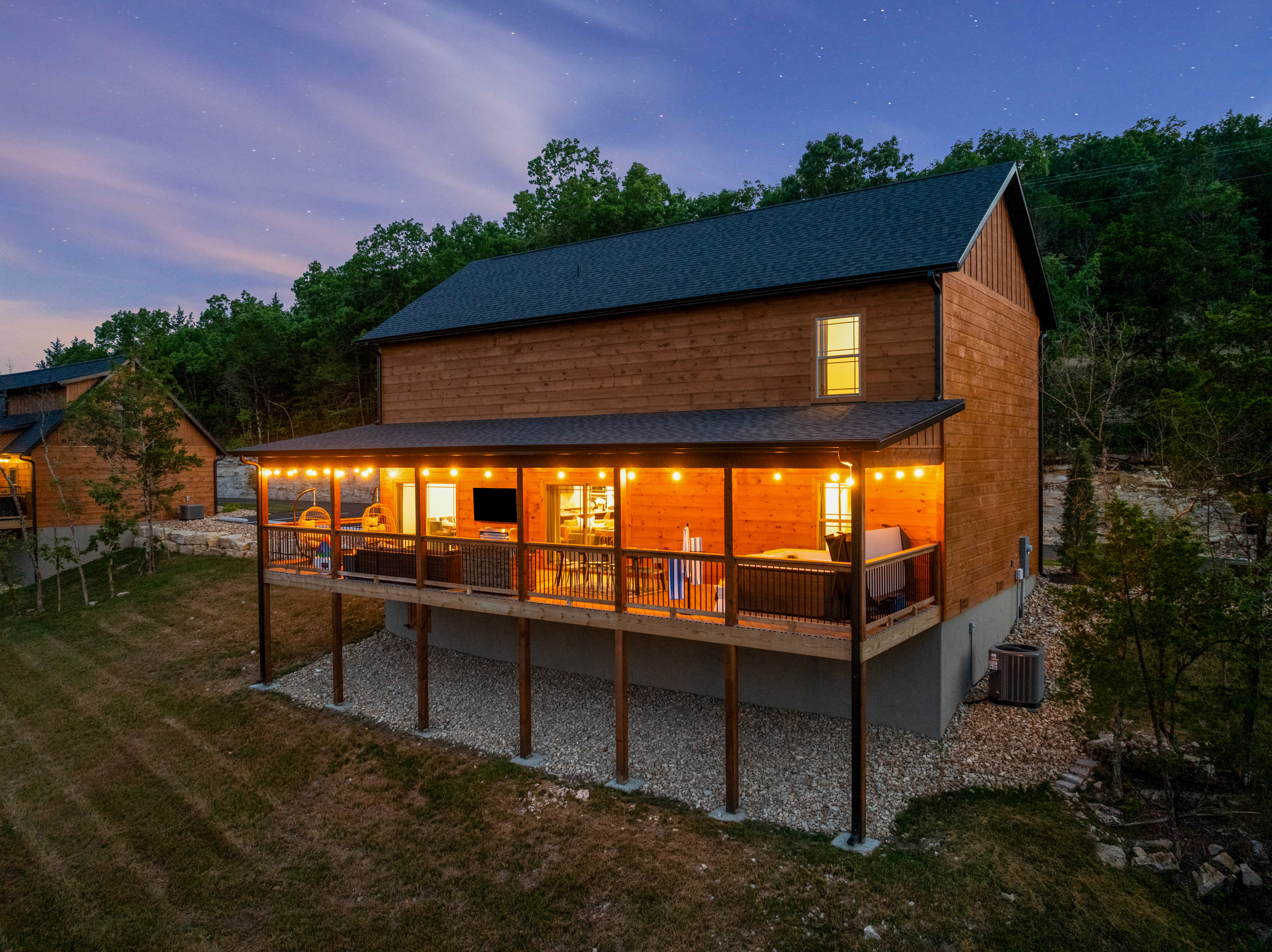 Welcome to Lone Star Lodge, a cedar cabin retreat in Hollister near Branson, Missouri, glowing at sunset with a private hot tub and Ozark Mountain views.