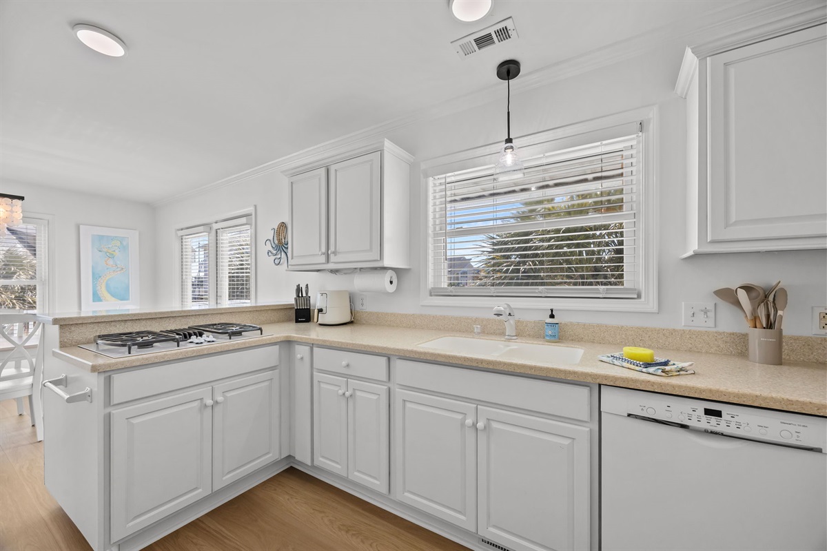 Bright and clean kitchen with dishwasher, sink, and spacious prep areas