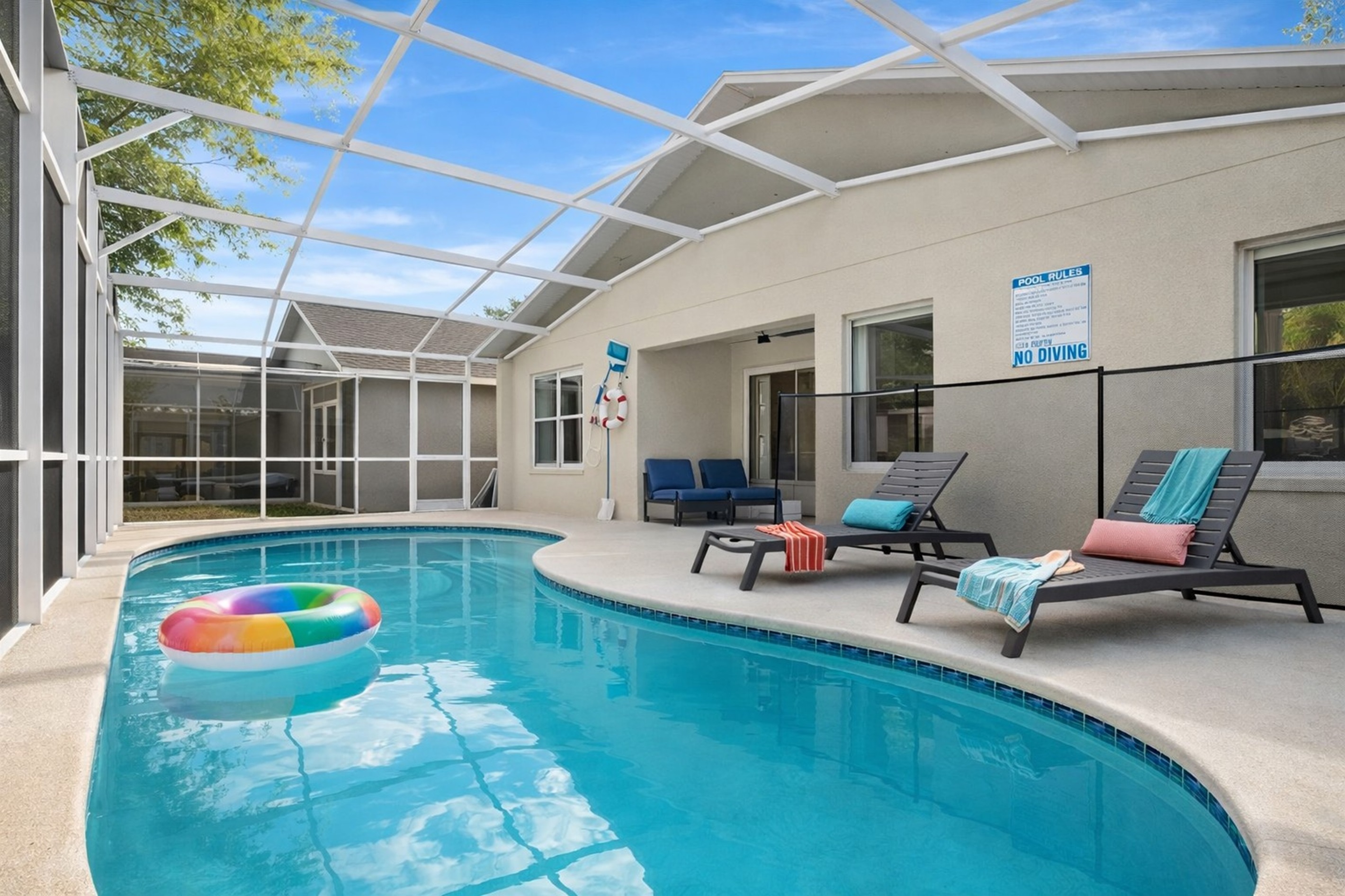 Relax by the private pool with comfortable lounge chairs in a screened patio area.