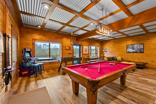 Game room with pool table, foosball, arcade games, and lounge seating — fun for all ages and great for family reunions