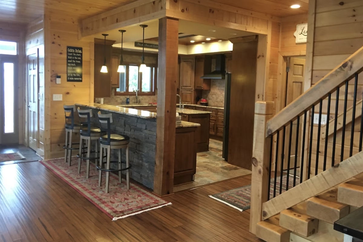 The breakfast bar overlooks the huge kitchen, fit with every pot, pan, bowl, and appliance you may need.