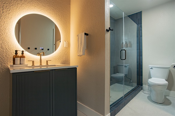 Newly renovated bathroom with single vanity and shower. Ensuite to bedroom 4 via pocket door and Bedroom 3 guests can access via hallway door. Build in shelves allow great storage for guests to keep all personal bathroom supplies  close too. 