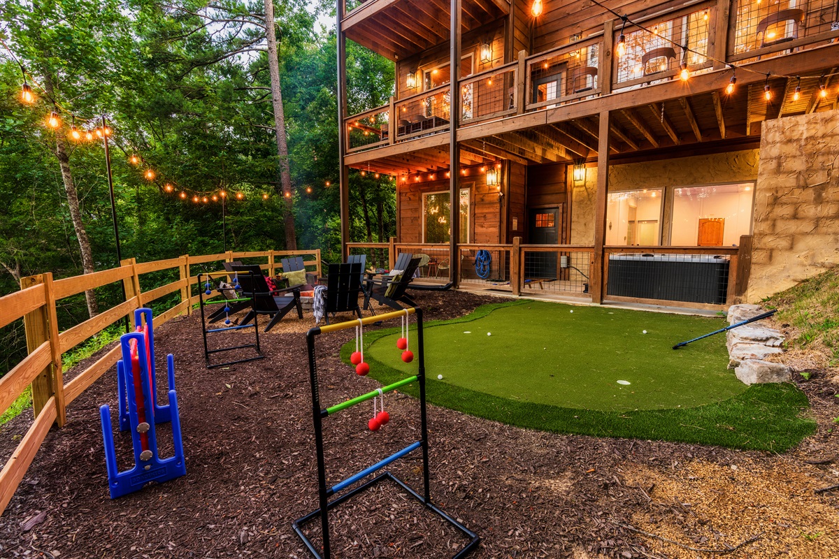 Luxury cabin with multiple decks, string lights, hot tub, and backyard with mini golf, fire pit, and outdoor games