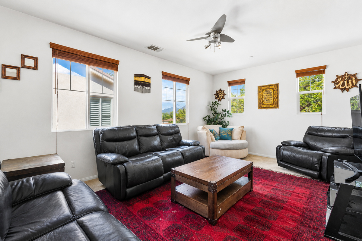Living room with leather seating, big windows, and a comfortable spot to relax together.
