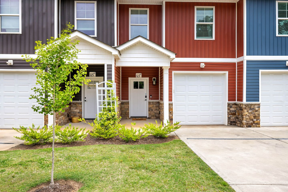 The cheerful red exterior is paired with a white front door and lantern-style lighting, giving a warm and inviting entrance to your stay.

