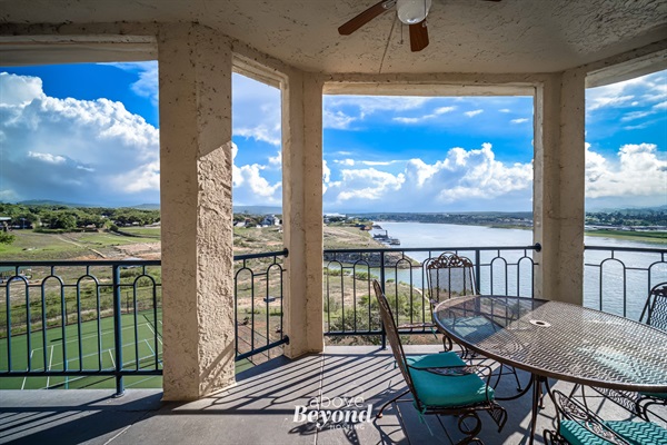 Spacious covered balcony with outdoor dining and panoramic Lake Travis views
