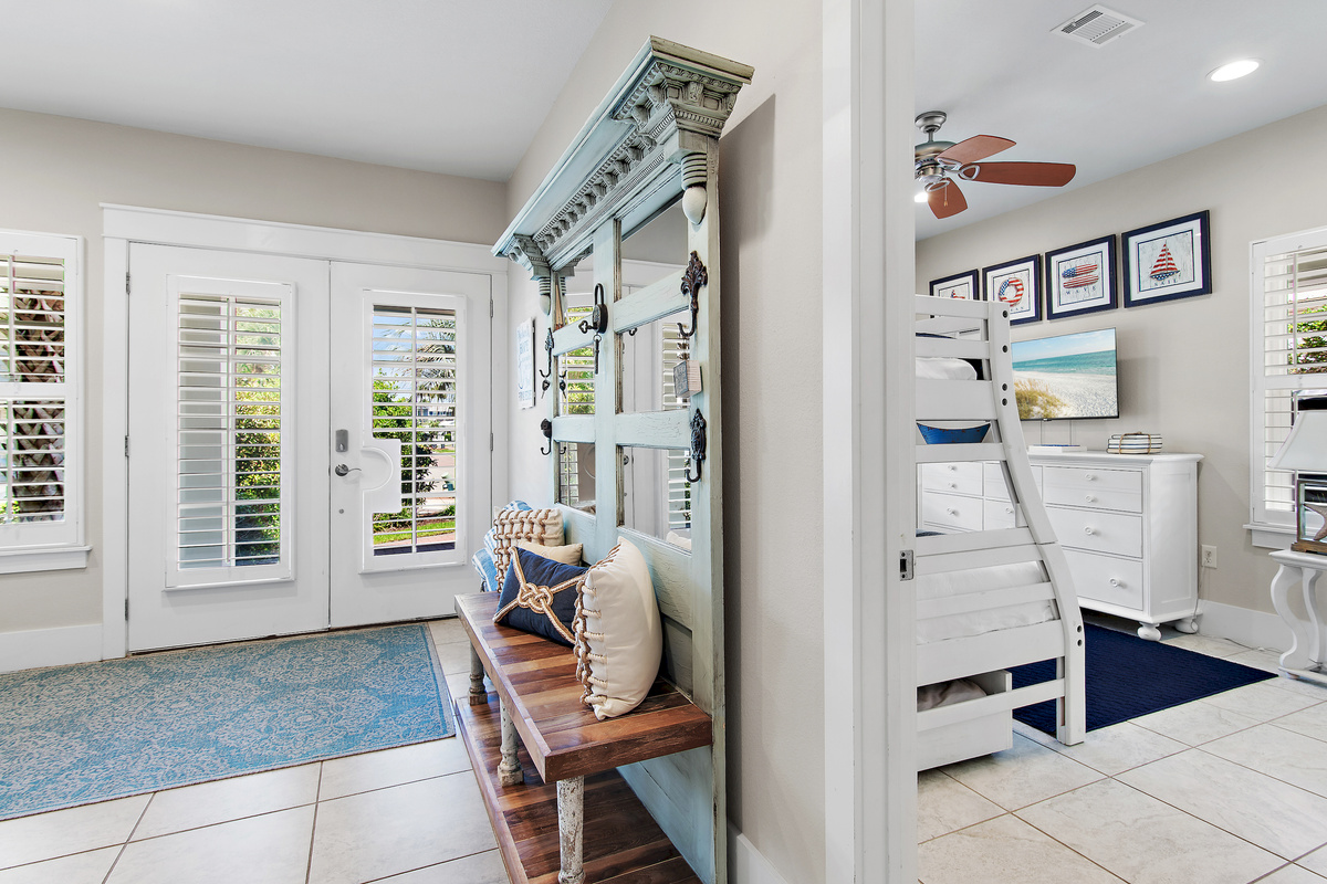 Bright coastal entryway with charming beach inspired décor, a welcoming bench, and beautiful details throughout.