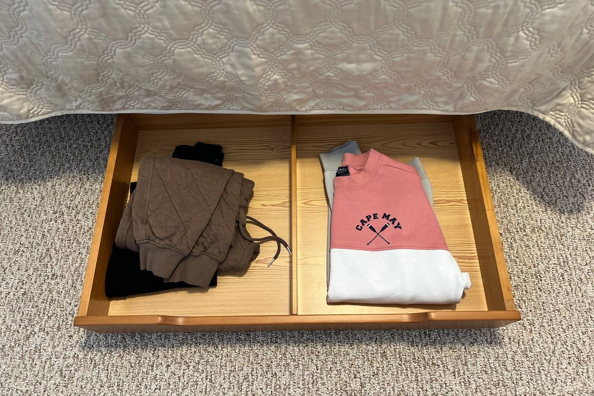 Additional clothes storage in a roll away drawer under the bed