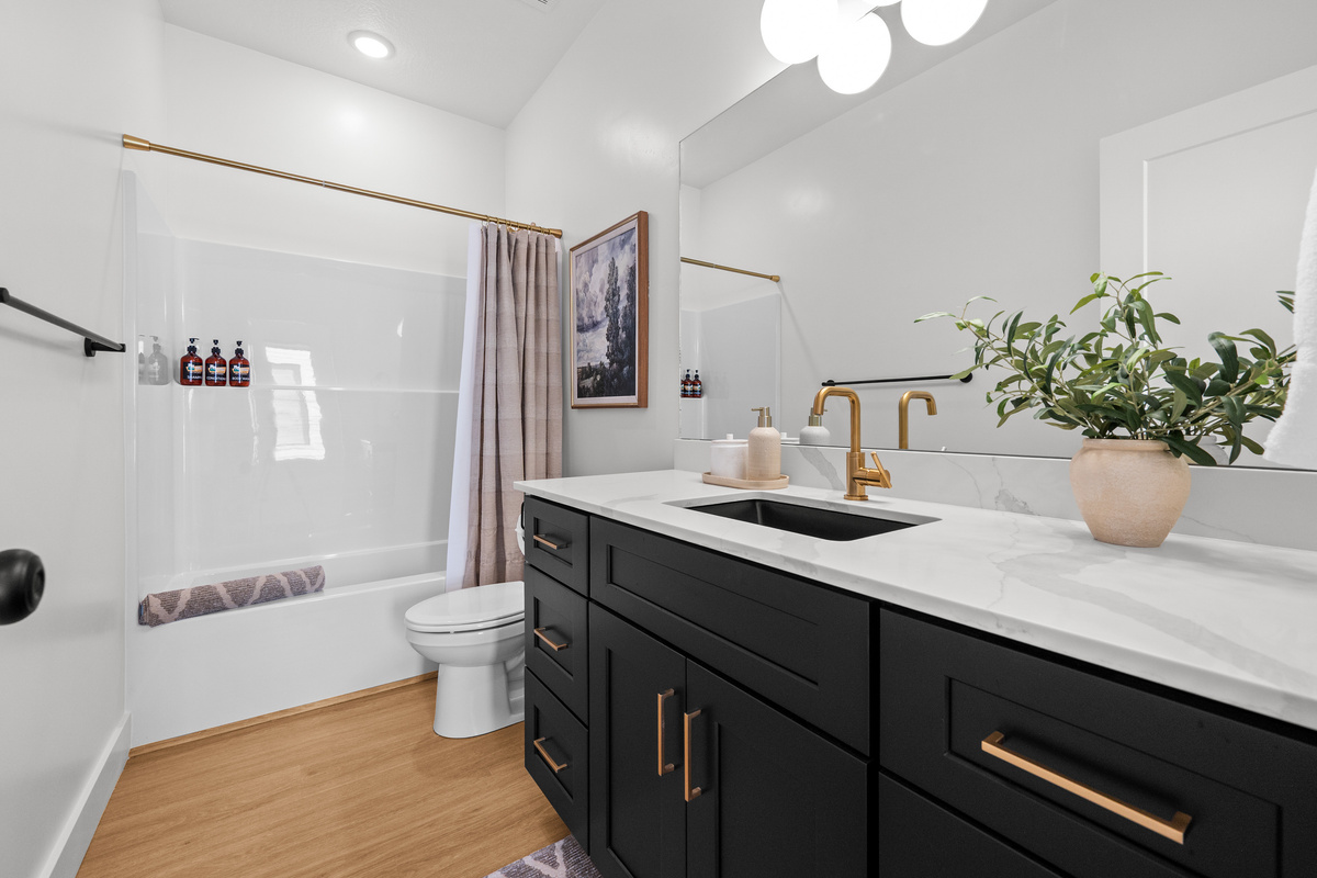 Another bright full bathroom with a spacious vanity, tub/shower combination, and clean modern finishes.