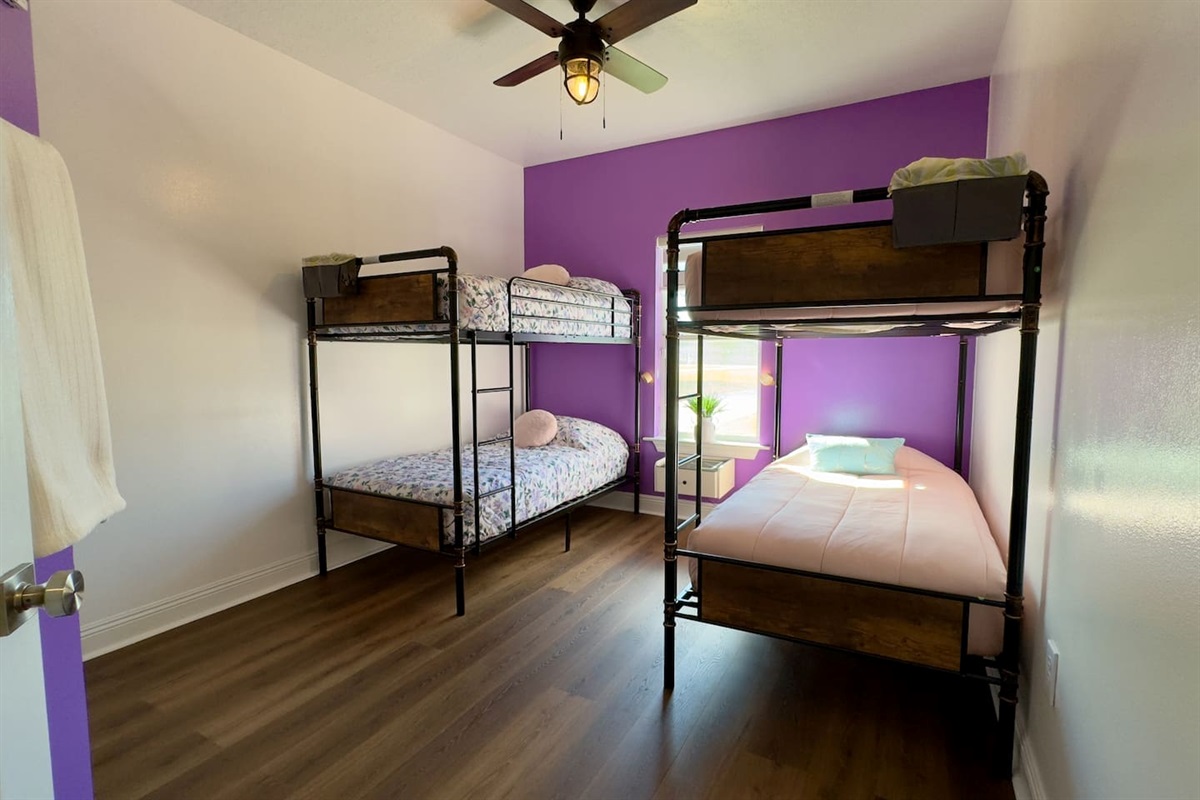 A neatly arranged bedroom with two sturdy metal bunk beds, offering four sleeping spaces in total