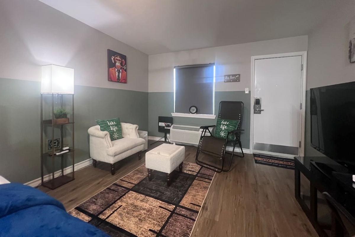 Living space with a TV, accent chairs, and a simple spot to relax or watch a show.
