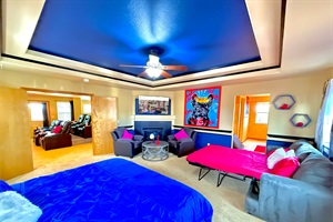 Grandeur master's bedroom featuring a king bed, queen pull-out couch, cozy armchairs, and a Smart TV—an ideal space for ultimate relaxation and comfort