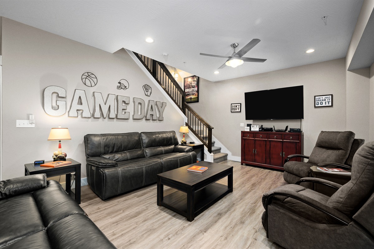 Main level living area with 65" TV, electric fireplace, and fully reclining leather chairs