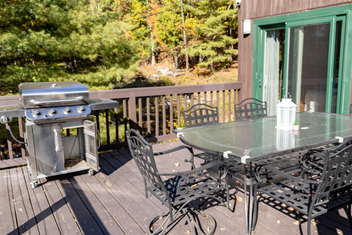 Deck top with grill and patio table overlooking forest — cook, dine, relax.