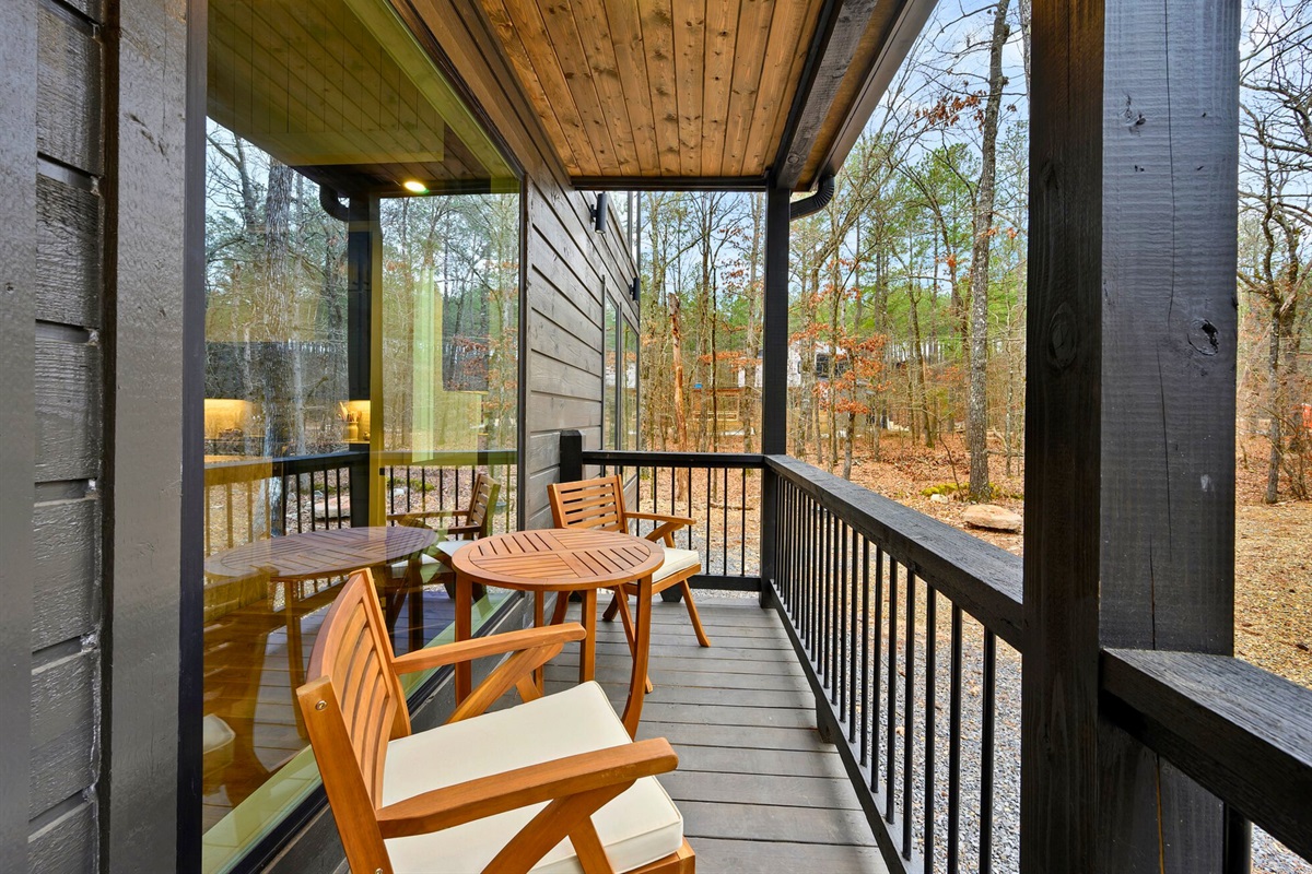 A small sitting area on the balcony lets you enjoy a slower pace surrounded by trees.