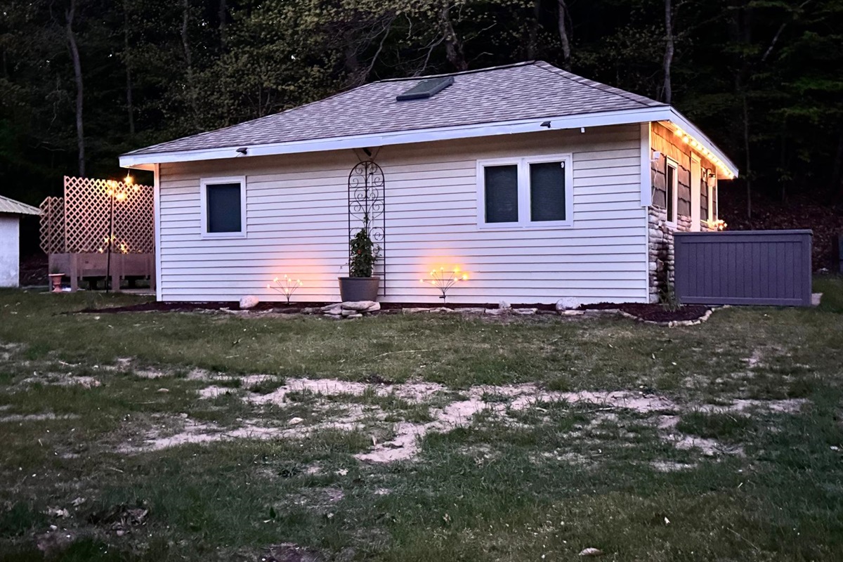 Back patio with a bistro set, umbrella, solo stove, charcoal grill and romantic string lights to enhance your stay.
