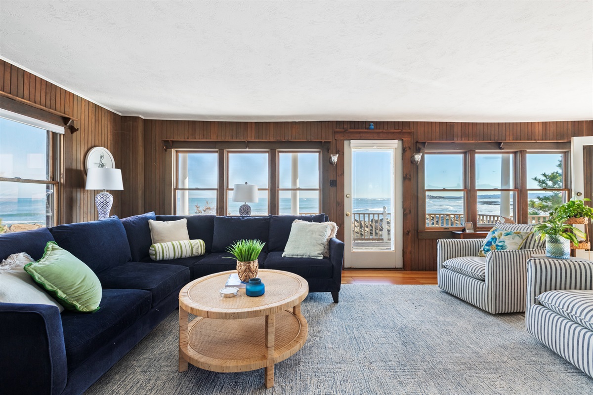 Bright coastal living space with panoramic ocean views, cozy seating, and direct access to the private deck, perfect for relaxing to the sound of the waves. 🌊