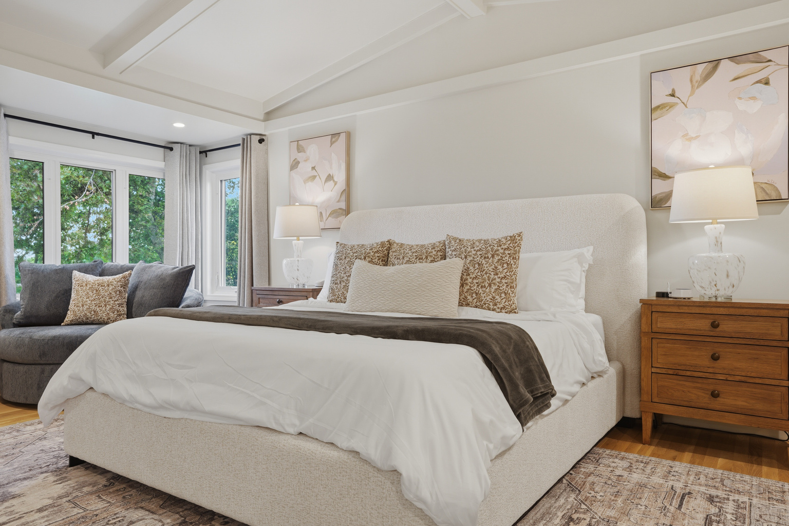 Retreat to this beautifully appointed primary bedroom featuring a plush king-size bed, elegant furnishings, and large windows that fill the space with natural light.