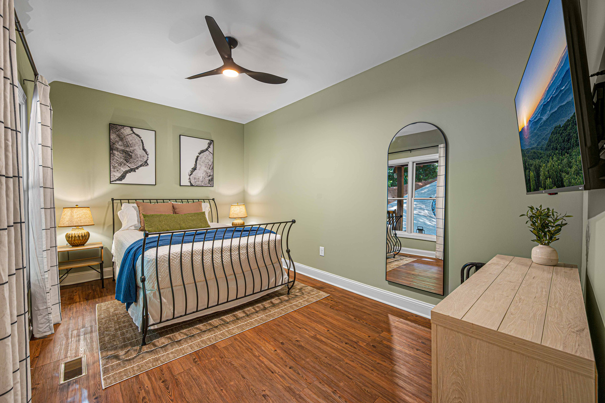 Main-level Queen bedroom with Smart TV and nearby full bathroom.