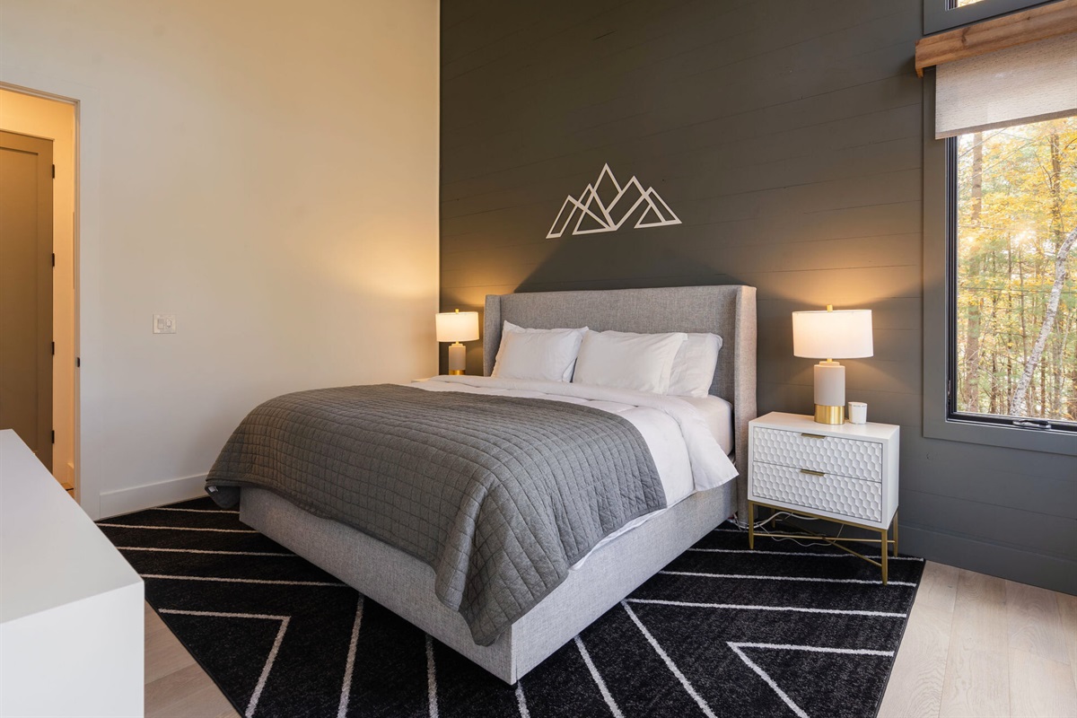 This king bedroom offers a soft, inviting ambiance with plush bedding and natural light streaming in.