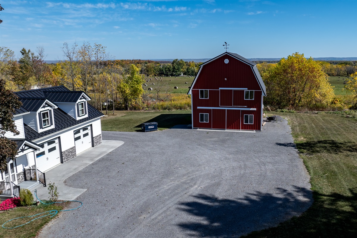 Aerial view of the charming red barn and main home — rustic elegance meets modern comfort