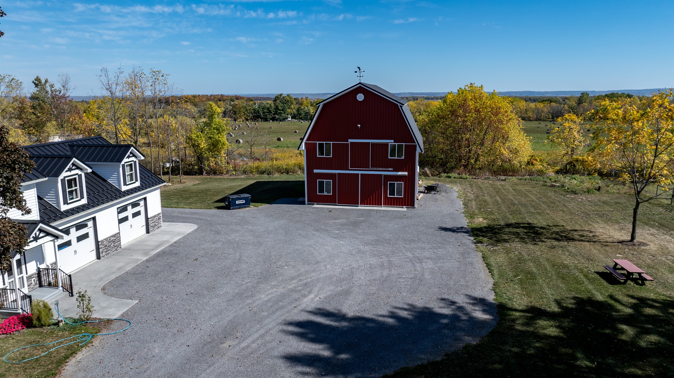 Aerial view of the charming red barn and main home — rustic elegance meets modern comfort