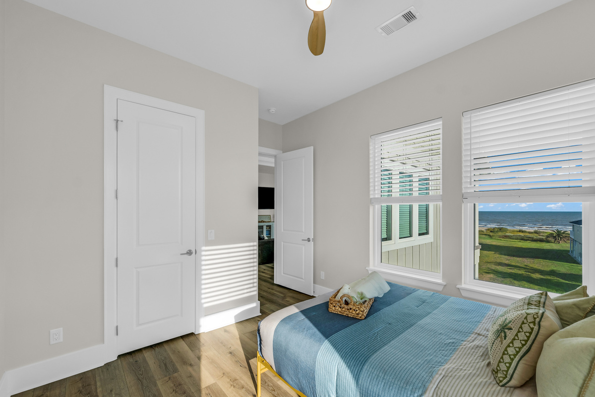 Costa Cristal Bedroom 2: Cozy queen bed with large windows, natural light, and relaxing views. Perfect for a restful night’s sleep.