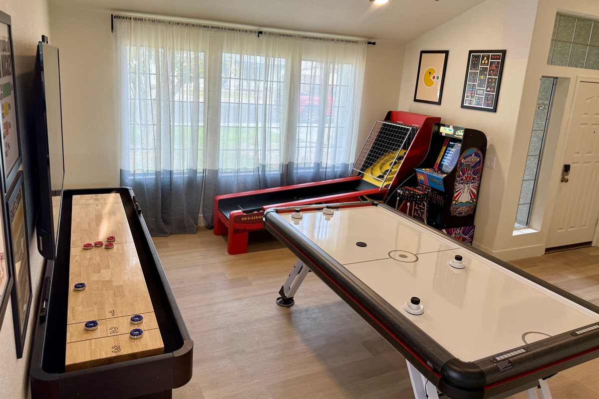 Game room with full-size air hockey, shuffleboard, skee ball, Multi-Game Standing Ms PacMan Multi-Game Machine, & Smart TV