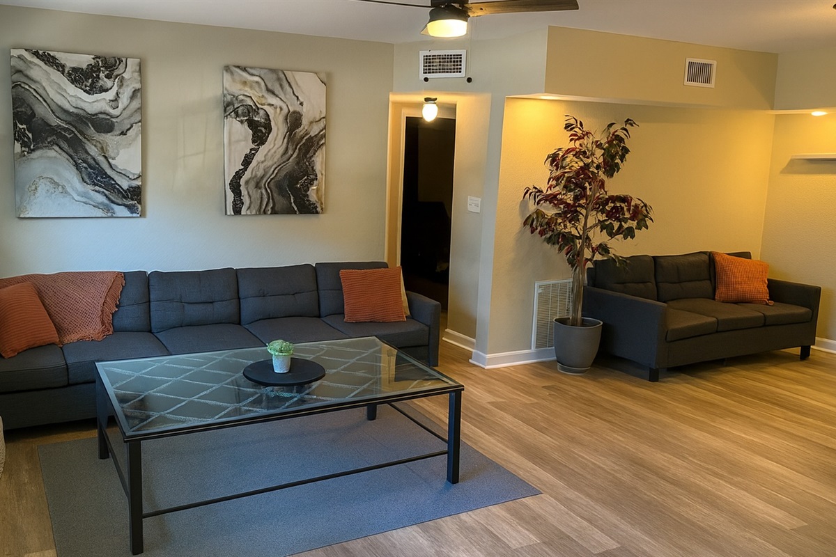 Cozy living room with comfy seating, chic decor and flat-screen TV—perfect for relaxing after a day at Madeira Beach or exploring Johns Pass near our midterm rental in Seminole, FL.