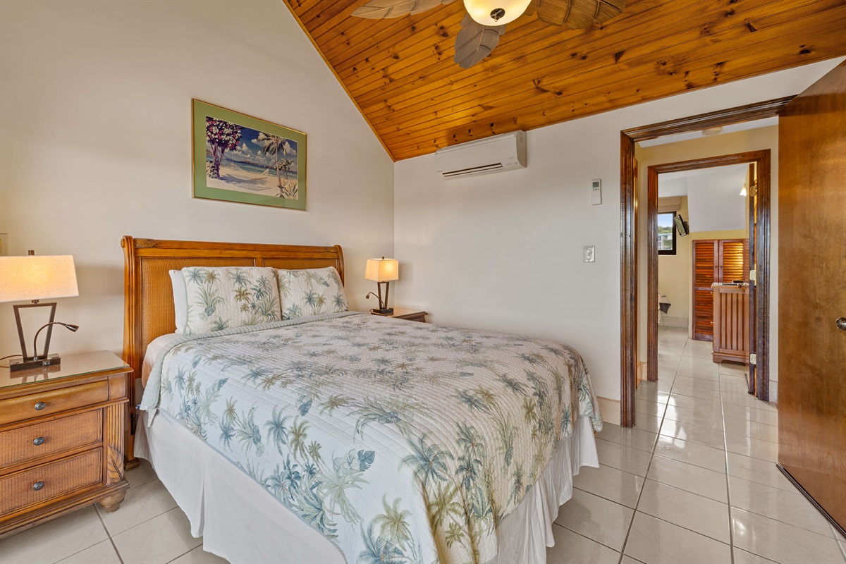 Primary bedroom with Queen bed, ceiling fan, TV and balcony