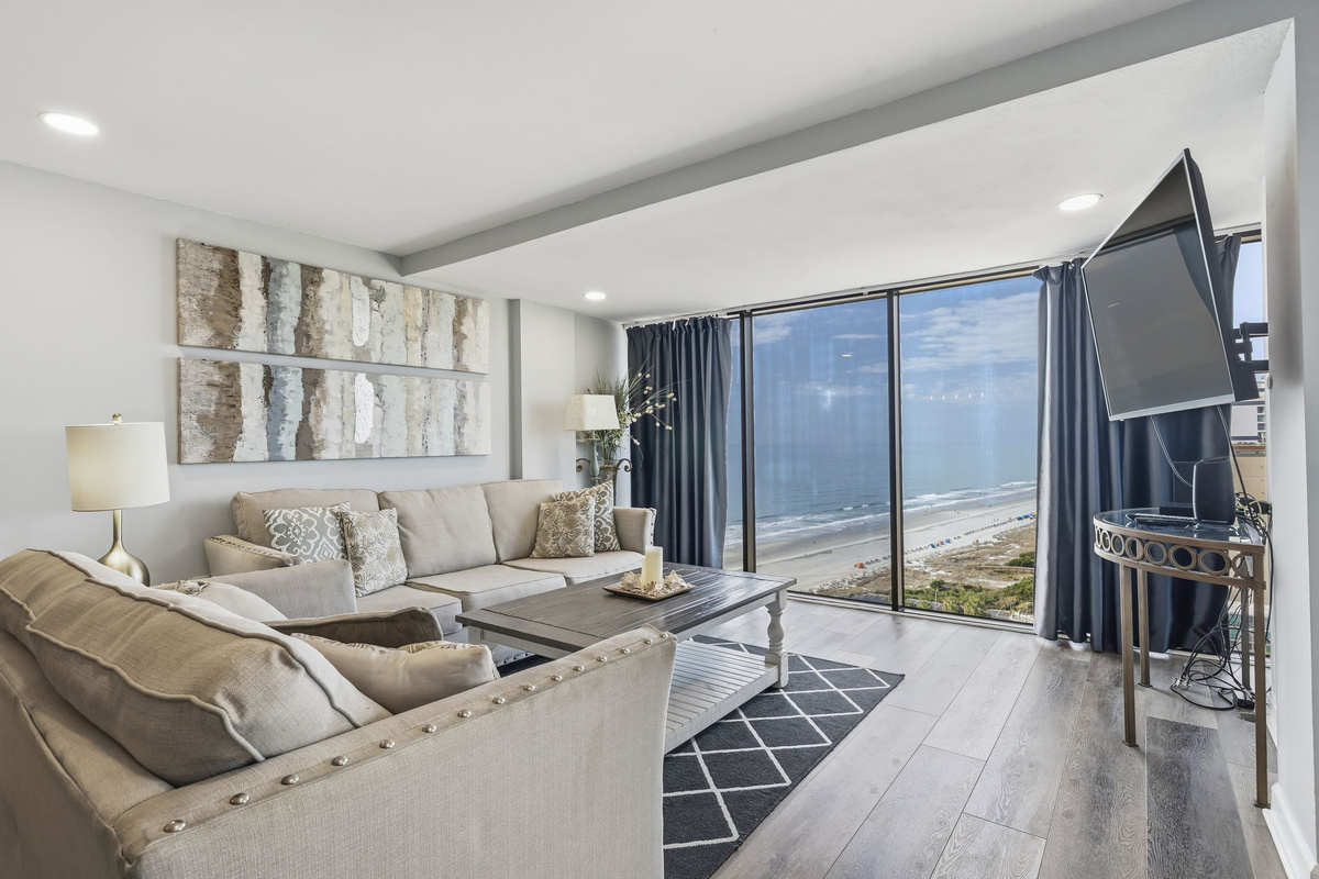 Penthouse living room with floor-to-ceiling windows overlooking the ocean