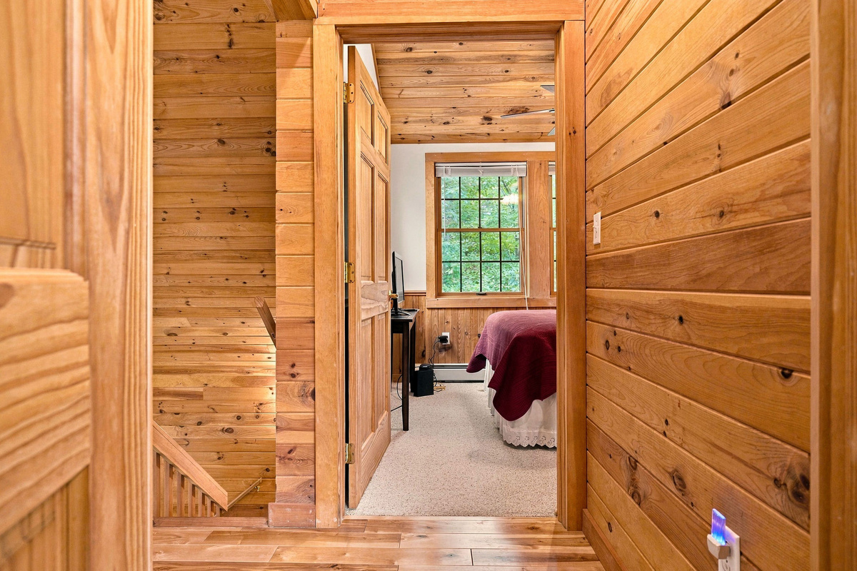 A warm wood hallway connects the lodge’s comfortable sleeping areas.