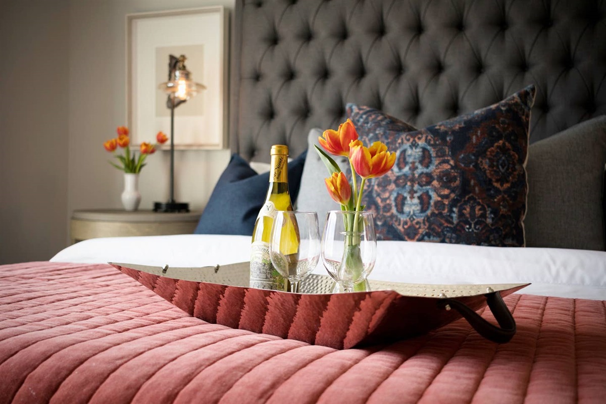 - Decorative tray with wine, glasses, and tulips sets a warm, elegant tone upon arrival - Tufted headboard, layered pillows, and rich textures add to the indulgent feel - Perfect for celebrating a special occasion or simply relaxing in style