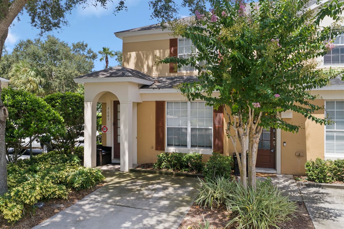 Front exterior of a two story villa with beautiful landscaping.

