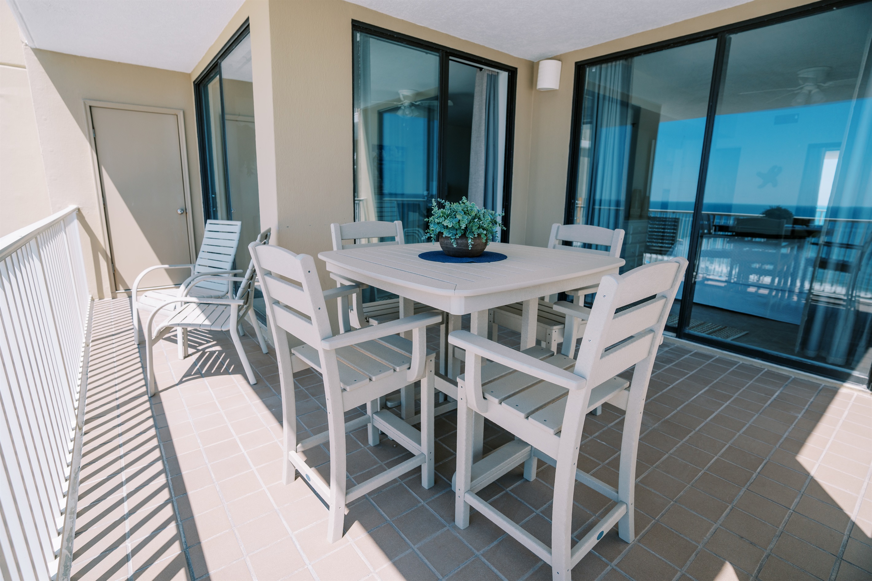 Three incredibly large floor-to-ceiling sliders overlooking the balcony and beachfront view.
