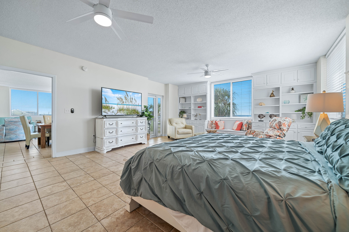 Experience the perfect blend of comfort and elegance in this well-appointed primary bedroom, complete with a large television, stylish dresser, and a soothing color scheme.