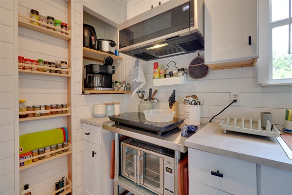 Cooking station features full size microwave, two burner induction cooktop and large toaster oven.