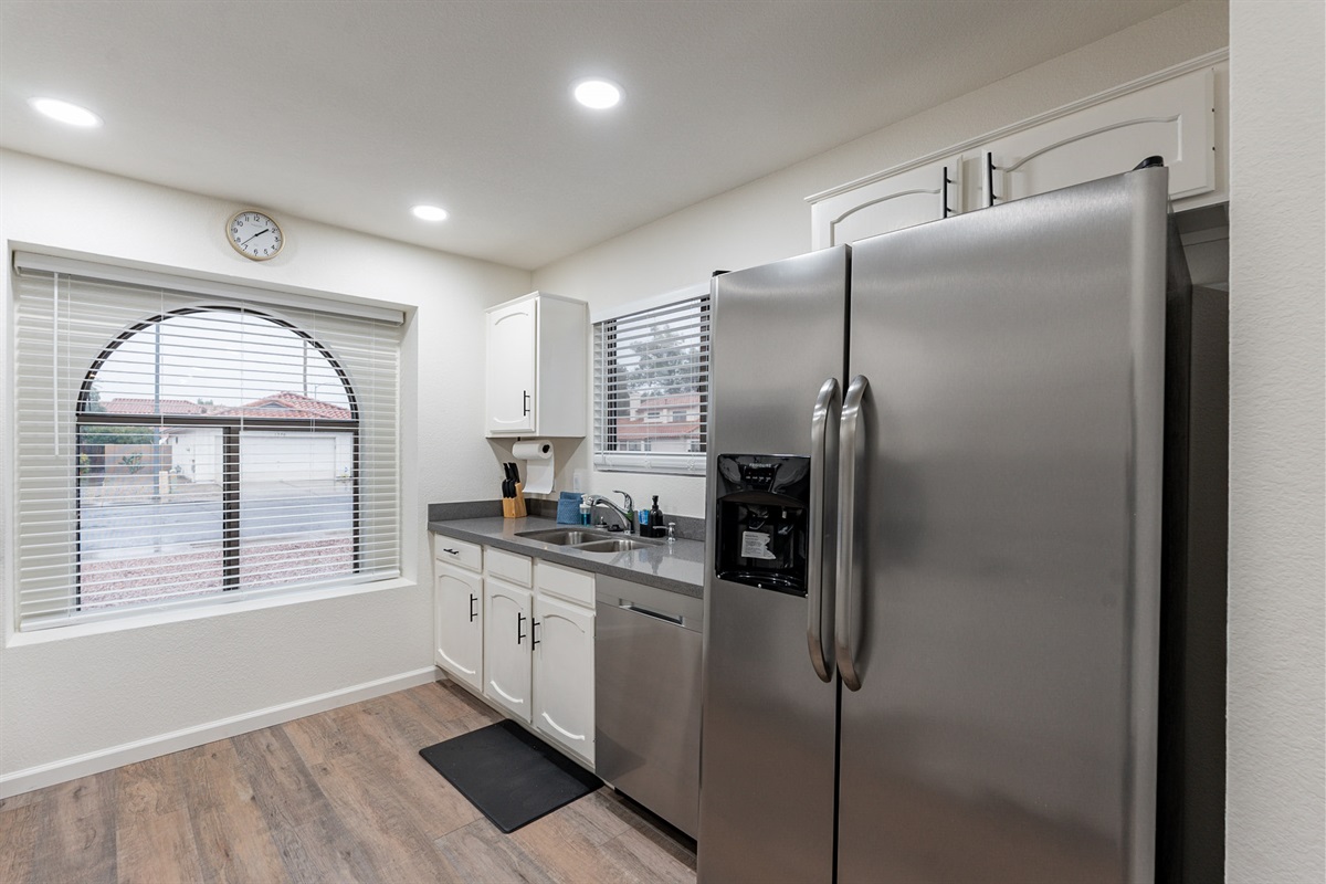 Kitchen with all new stainless steel appliances and small appliances including a coffee maker, crockpot, toaster and blender.