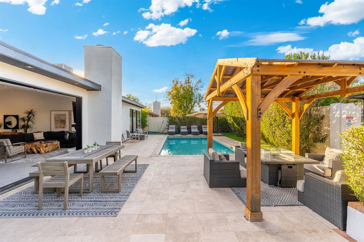 The outdoor dining table sits atop a textured rug and is styled with desert-hardy succulents—ready for breakfast or sunset cocktails.