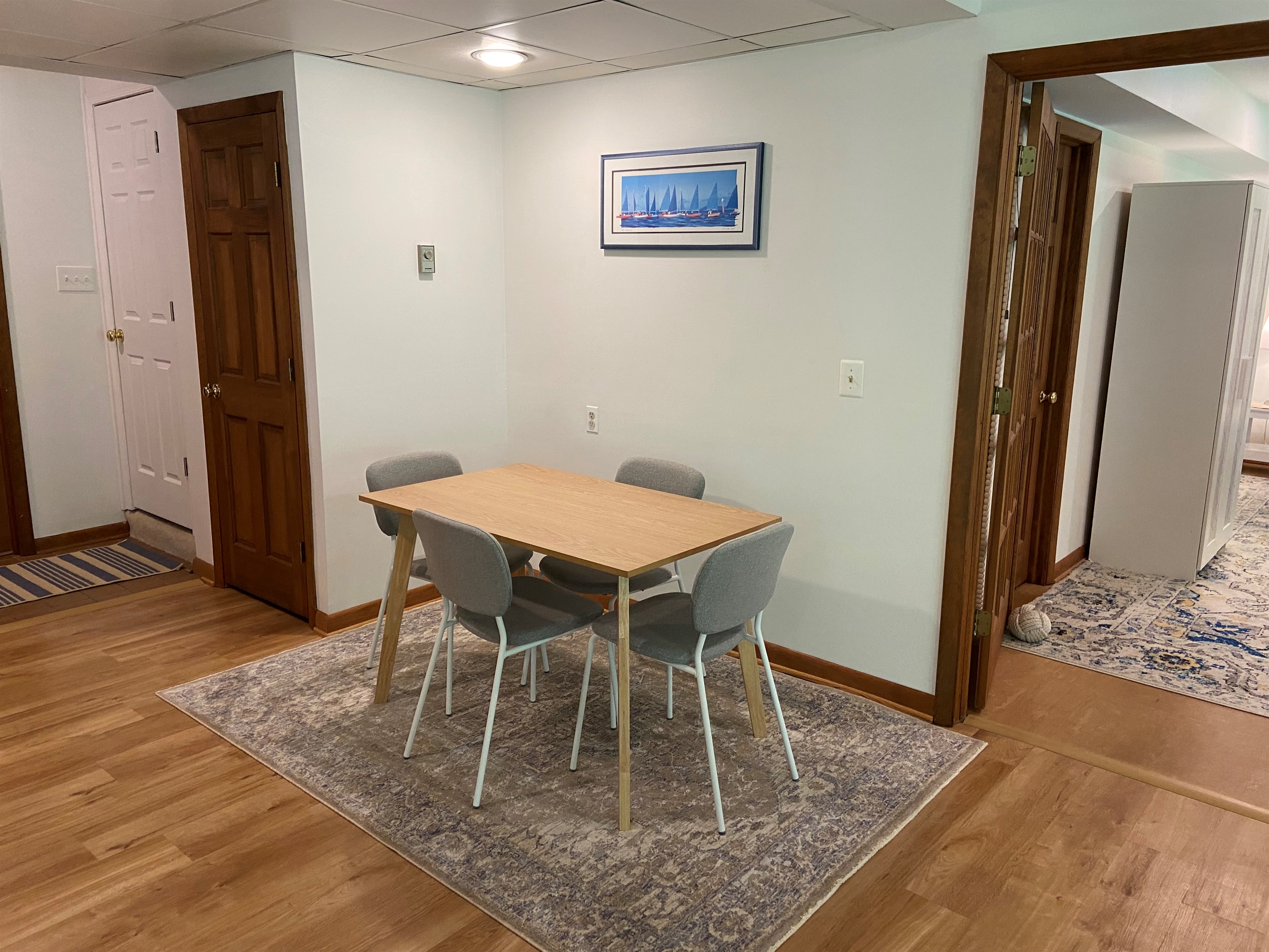 Dining area with view of the supply closet (brown door) and locked stairs to the owner's portion of the house (white door).