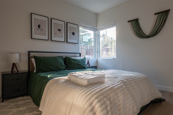 Queen bedroom with 33in Roku TV and garden views