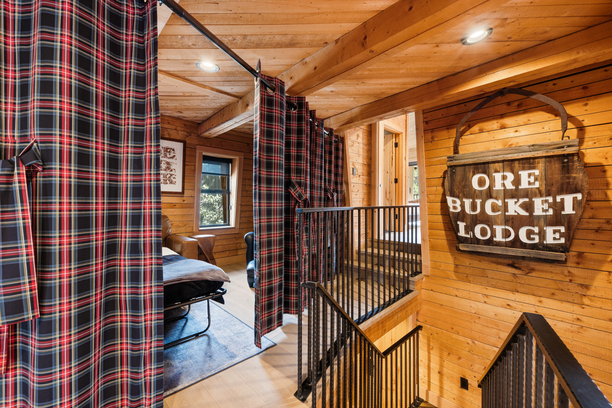 Upper level loft/multi-function living space. In this photo, the partition is partially closed, creating privacy for guests using the Queen sleeper sofa seating area as a bedroom. 