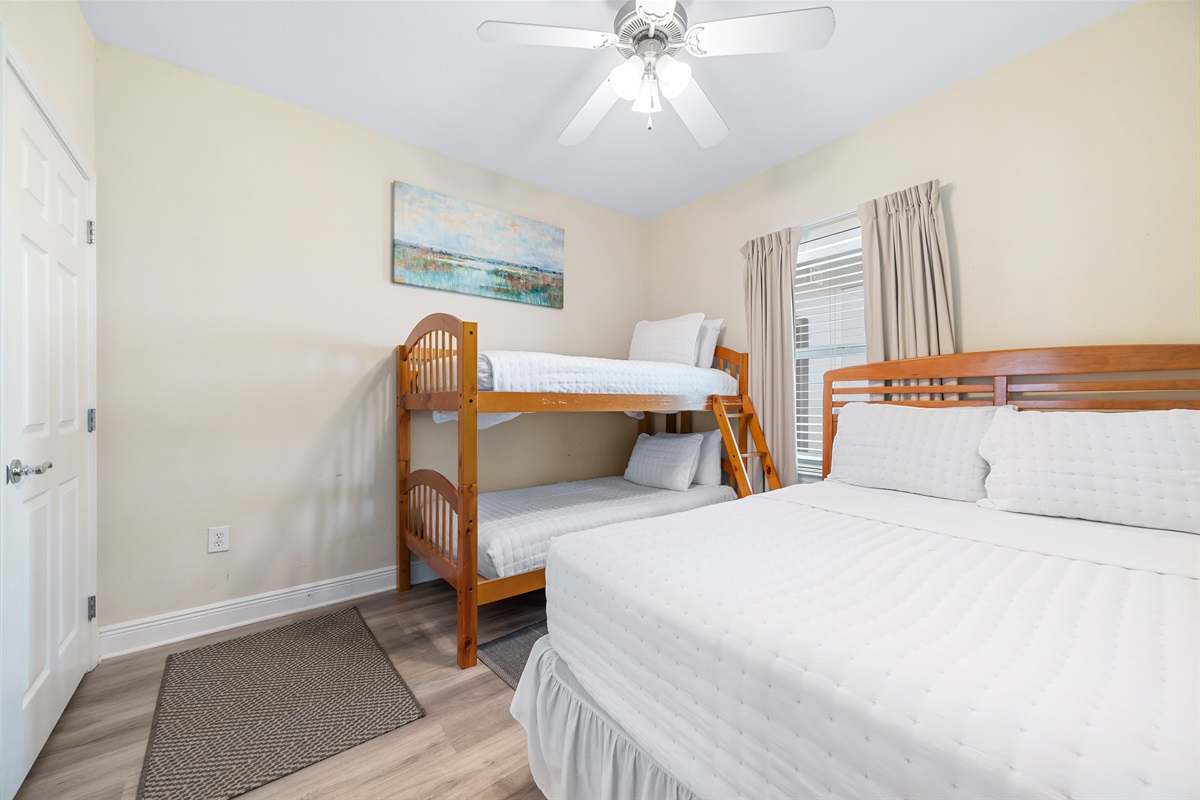 A cozy and inviting guest room with 1 queen-size bed and 1 bunk bed, perfect for creating memories and enjoying a comfortable stay. This space offers a blend of functionality and style.