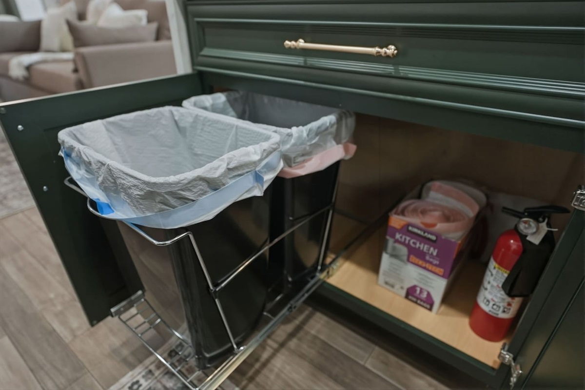 Built-in pull-out trash and recycling bins, plus extra trash bags and a fire extinguisher for safety and easy waste disposal.