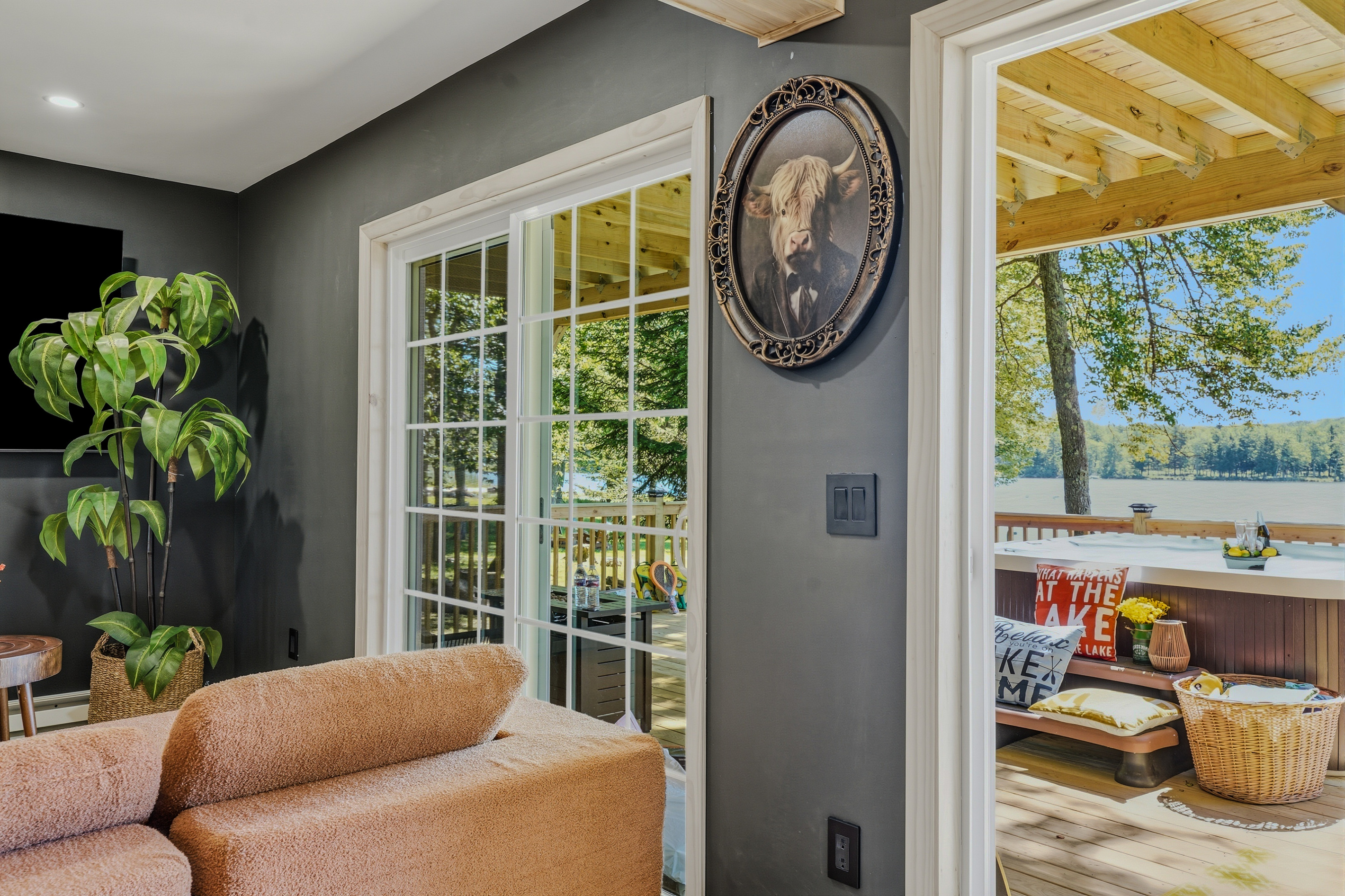 Lower-level living room with French doors, lake view, leather sofa, and globe art piece