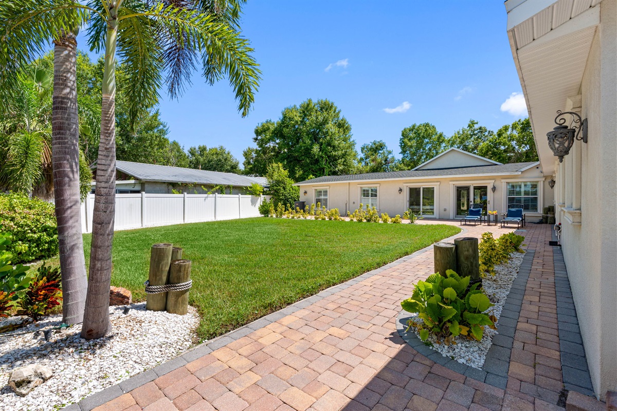 A well-maintained yard with palm trees, decorative stone beds, and fresh greenery brings a touch of paradise to everyday living.
