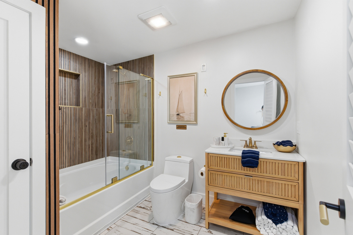 Shower and soaking tub combo that was recently completed remodeled with brass accents and timeless nautical details.