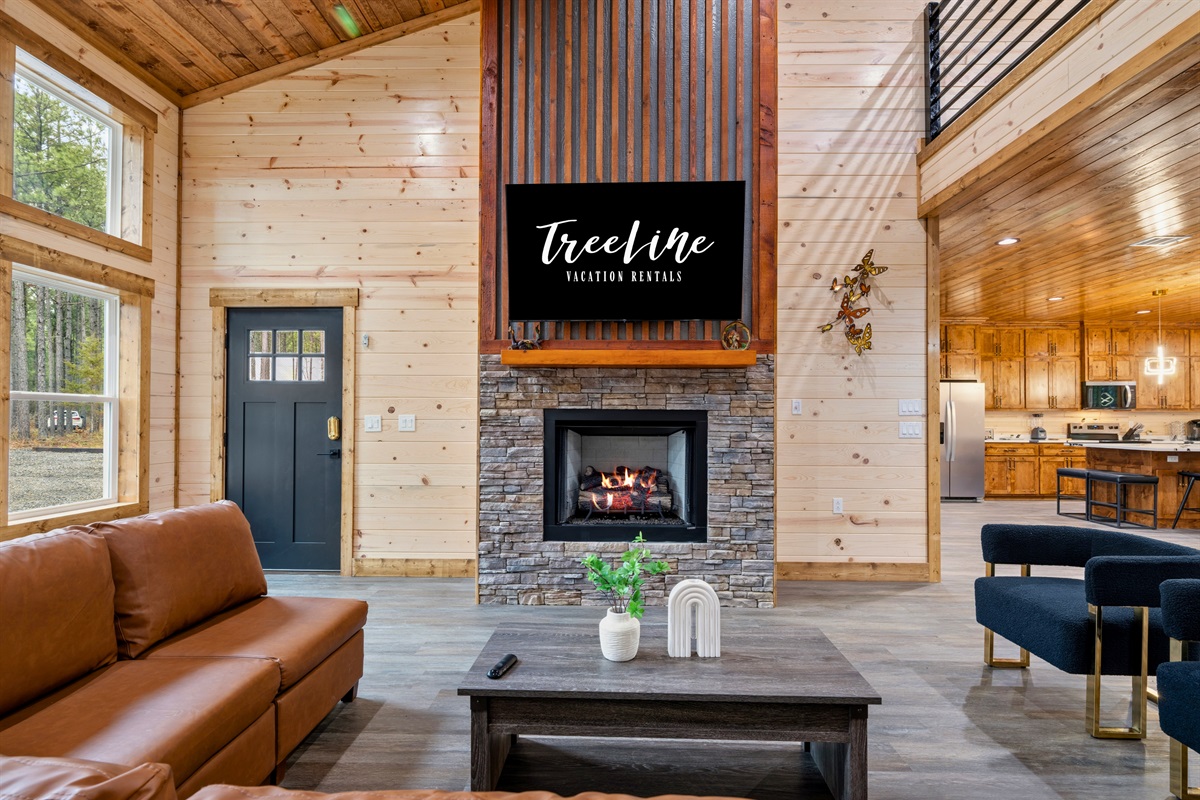 A bright and inviting sitting area near the fireplace offers another comfortable spot to chat, read, or simply enjoy the peaceful cabin atmosphere.