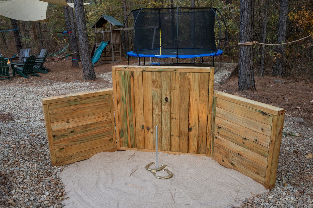Here’s a closer look at the horseshoe setup, complete with sand and sturdy wooden backboards, making it an easy and inviting place to play while hanging out in the fresh air.